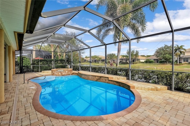 view of swimming pool featuring glass enclosure, an in ground hot tub, and a patio