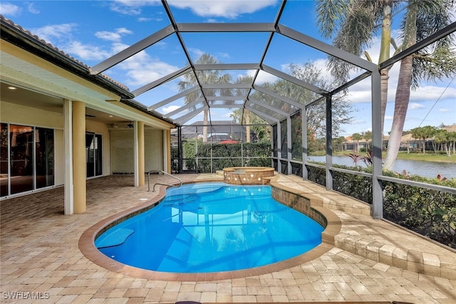 view of pool with an in ground hot tub, ceiling fan, a water view, glass enclosure, and a patio area