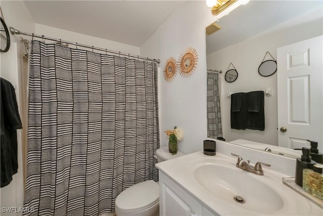 bathroom featuring vanity, toilet, and curtained shower