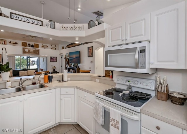 kitchen featuring sink, white cabinets, white appliances, and light tile patterned floors