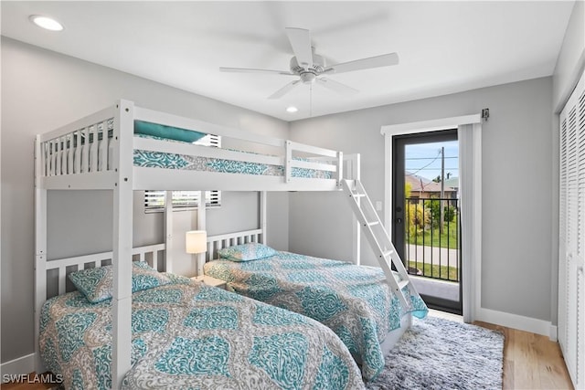 bedroom featuring hardwood / wood-style floors, ceiling fan, access to exterior, and a closet