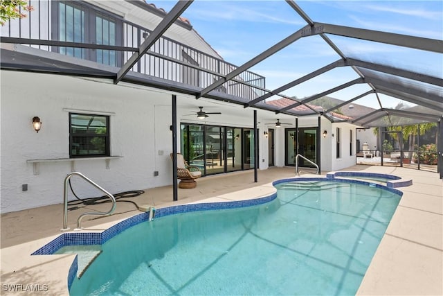 view of swimming pool featuring an in ground hot tub, a patio, ceiling fan, and a lanai