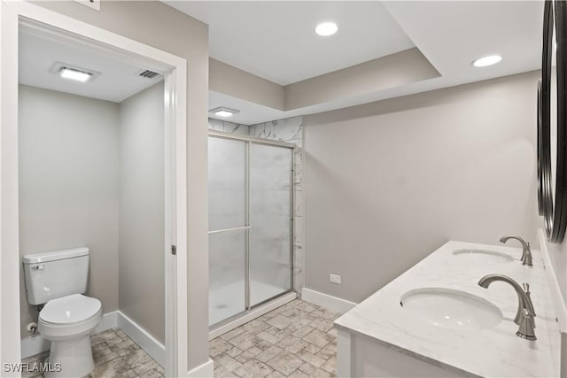 bathroom with vanity, a shower with shower door, and toilet