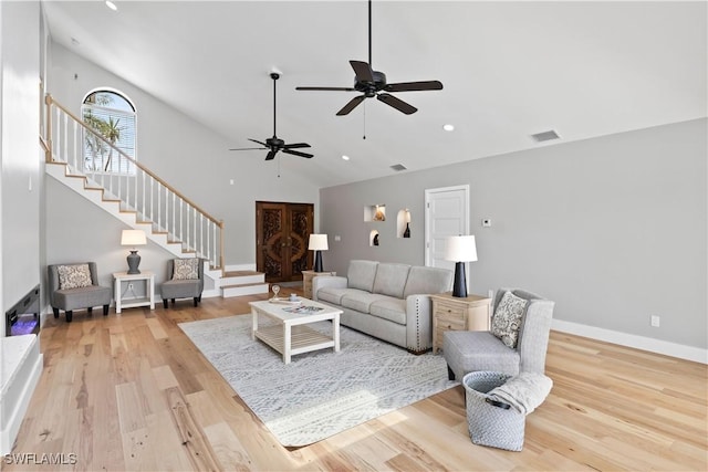 living room featuring ceiling fan, light hardwood / wood-style floors, and vaulted ceiling