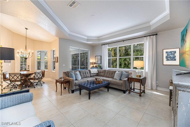 living room with an inviting chandelier, light tile patterned floors, and a tray ceiling