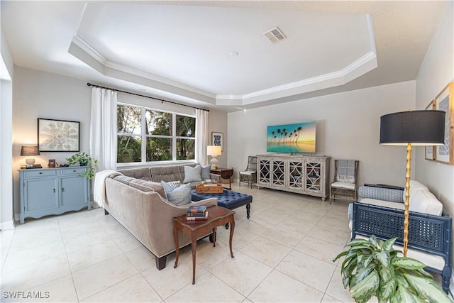 living room featuring light tile patterned floors, a tray ceiling, and ornamental molding