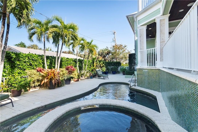 view of swimming pool featuring an in ground hot tub and a patio