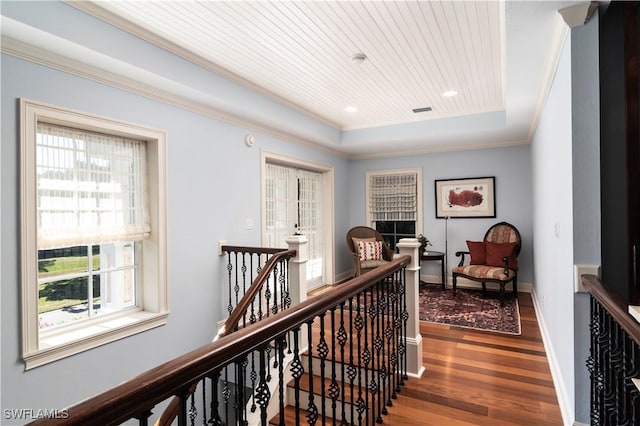 corridor with dark hardwood / wood-style flooring, ornamental molding, wooden ceiling, and a raised ceiling