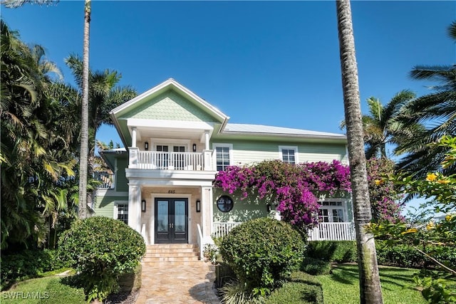 view of front of house with a balcony and french doors