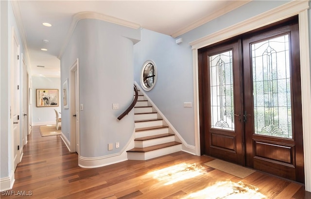 foyer entrance featuring crown molding, french doors, and hardwood / wood-style flooring