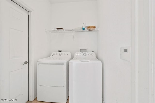 clothes washing area with washer and clothes dryer