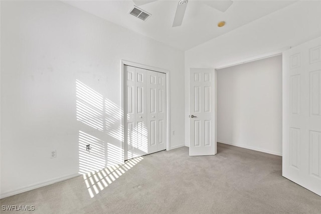 unfurnished bedroom featuring ceiling fan, light carpet, and a closet