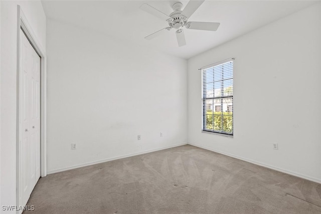 unfurnished bedroom with ceiling fan, a closet, and light carpet