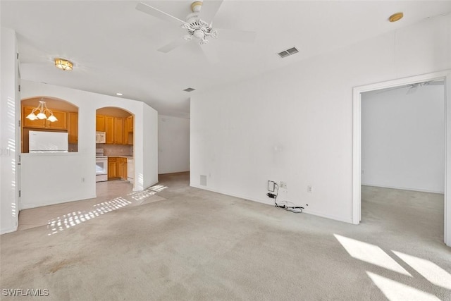 unfurnished living room featuring ceiling fan with notable chandelier and light colored carpet