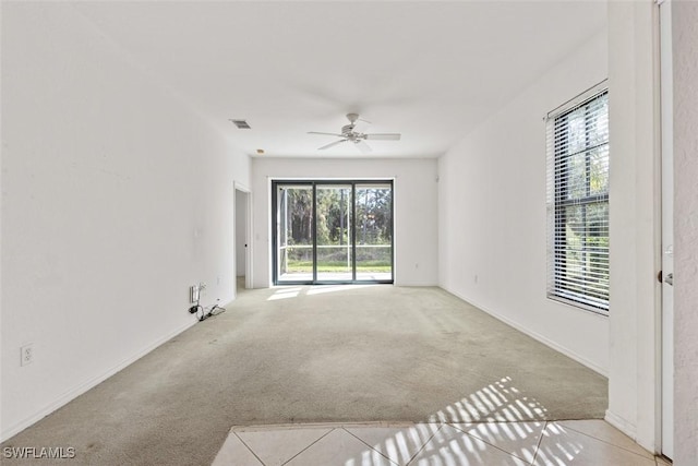 unfurnished living room featuring ceiling fan, a healthy amount of sunlight, and light carpet