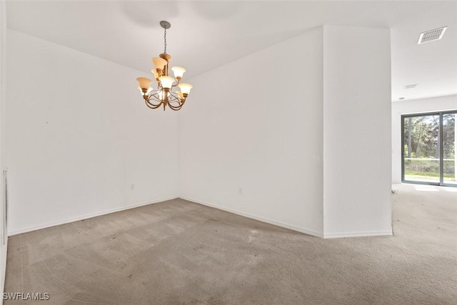 unfurnished room with an inviting chandelier and carpet flooring