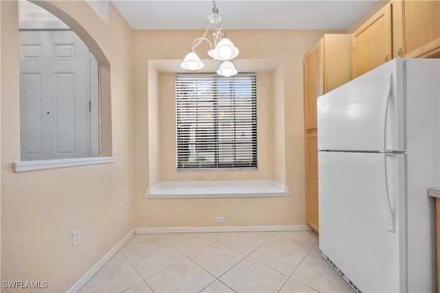 kitchen with pendant lighting, light brown cabinets, white refrigerator, a chandelier, and light tile patterned flooring