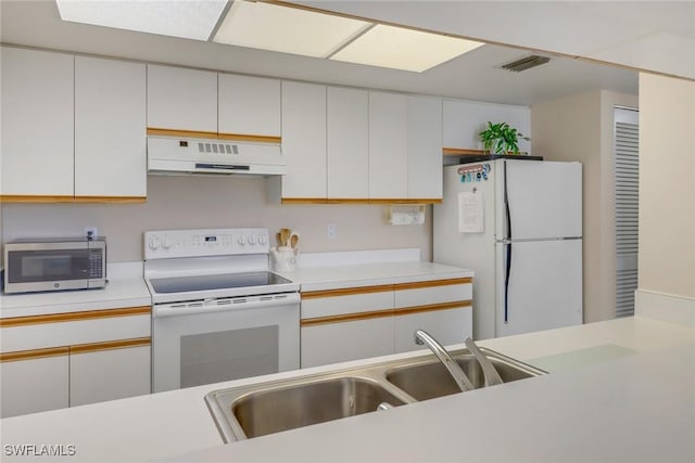 kitchen featuring sink, white cabinets, and white appliances