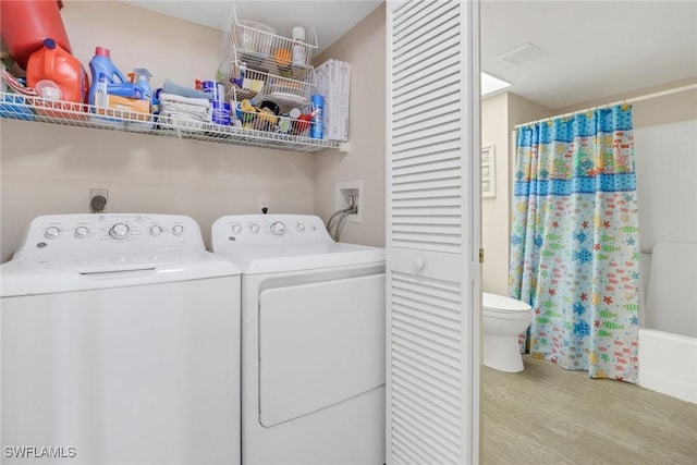 washroom with light wood-type flooring and washing machine and clothes dryer