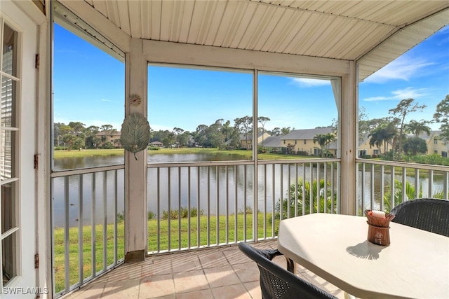 sunroom / solarium featuring a water view