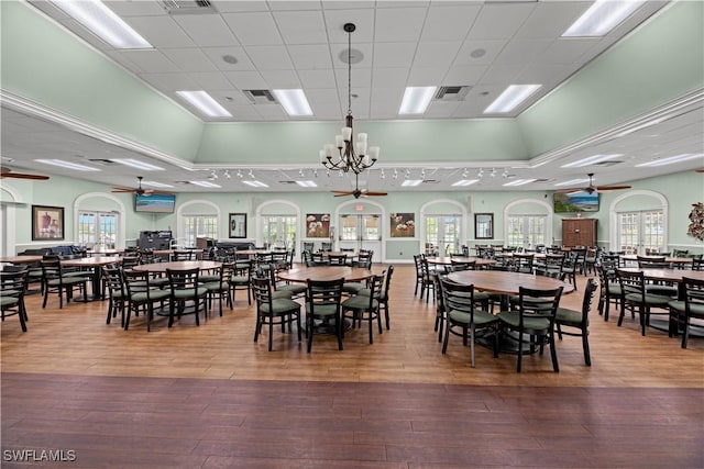 dining room with wood-type flooring and ceiling fan with notable chandelier