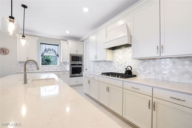 kitchen featuring light stone countertops, sink, decorative light fixtures, appliances with stainless steel finishes, and custom exhaust hood