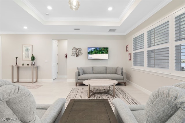 living room with a raised ceiling and crown molding