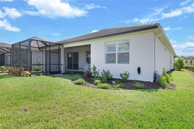 rear view of house featuring a lanai and a yard