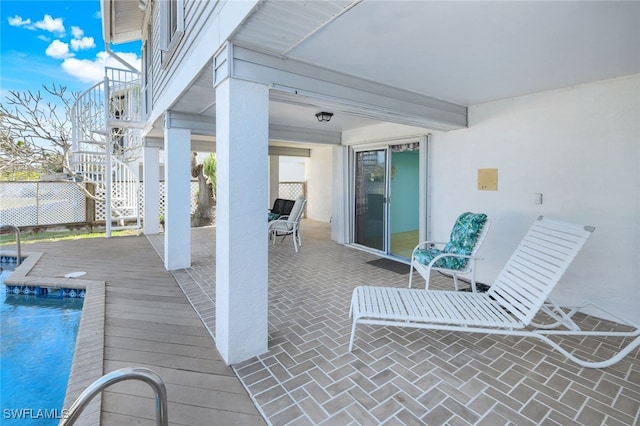 view of patio / terrace featuring stairway, fence, and a fenced in pool