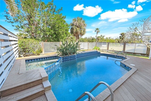 view of pool featuring pool water feature and a deck