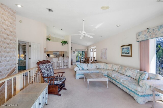 living room with light carpet, vaulted ceiling, and ceiling fan