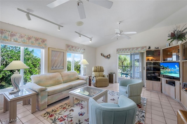 living area with vaulted ceiling, a ceiling fan, and light tile patterned flooring