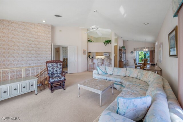 living room with high vaulted ceiling, light colored carpet, and ceiling fan