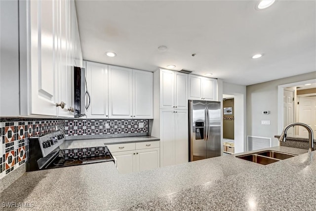 kitchen featuring appliances with stainless steel finishes, light stone countertops, sink, white cabinets, and tasteful backsplash