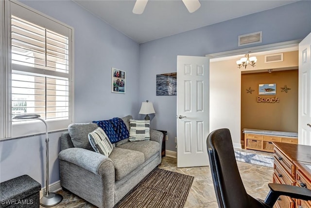 office space featuring ceiling fan with notable chandelier