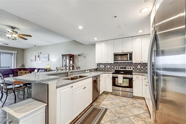 kitchen with sink, white cabinetry, kitchen peninsula, and appliances with stainless steel finishes