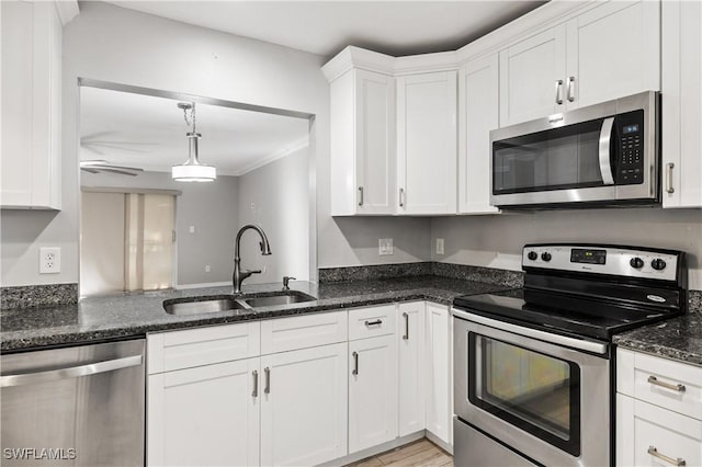 kitchen featuring white cabinetry, appliances with stainless steel finishes, sink, and dark stone counters