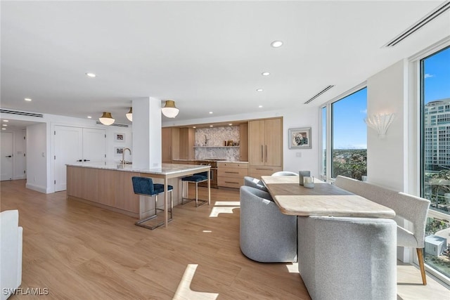 dining room with sink, expansive windows, and light hardwood / wood-style floors