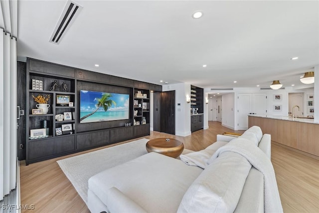 living room featuring light hardwood / wood-style floors and built in shelves