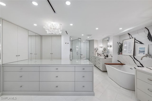 bathroom featuring vanity and independent shower and bath