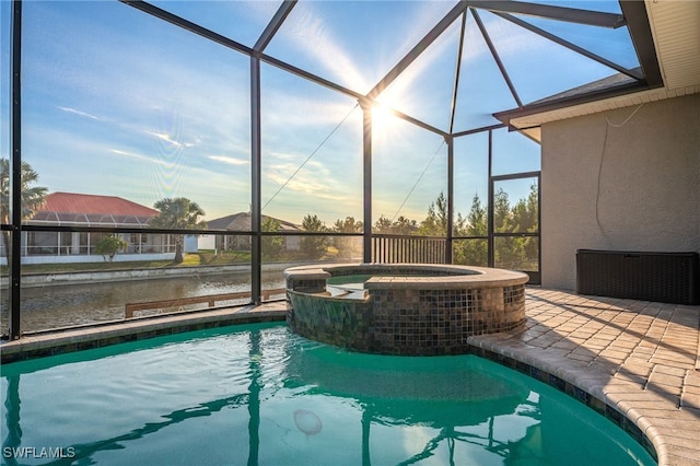 view of swimming pool with an in ground hot tub, a lanai, and a patio