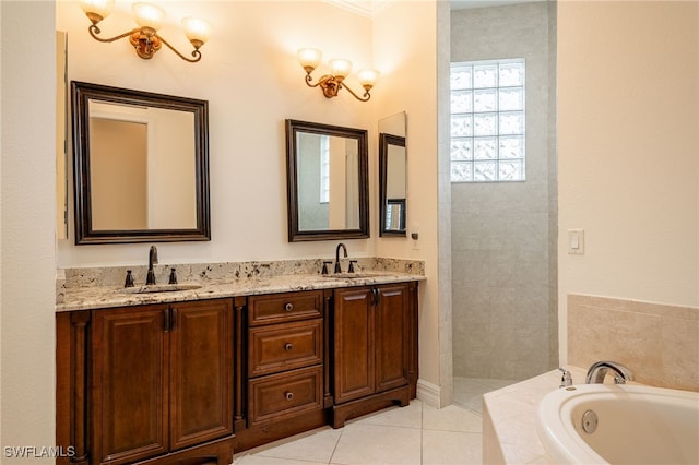 bathroom featuring tiled tub, vanity, and tile patterned flooring