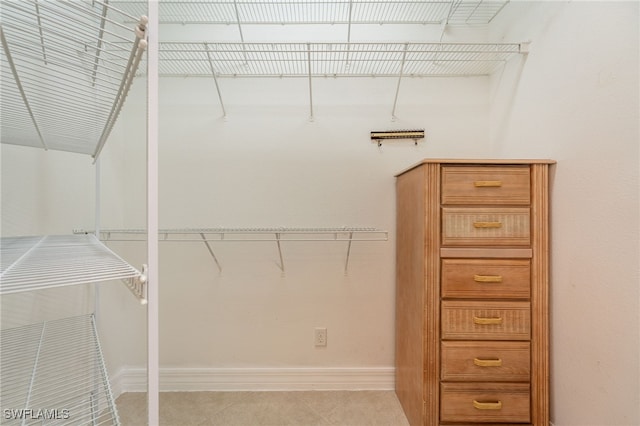 walk in closet with light tile patterned floors