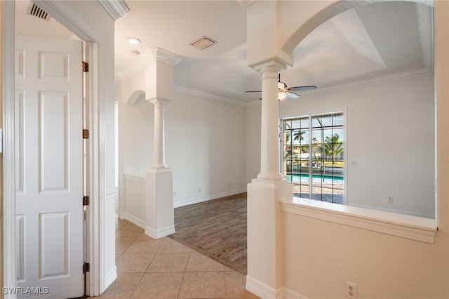corridor featuring decorative columns, crown molding, and light tile patterned floors