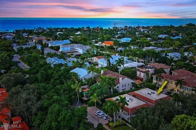 aerial view at dusk featuring a water view