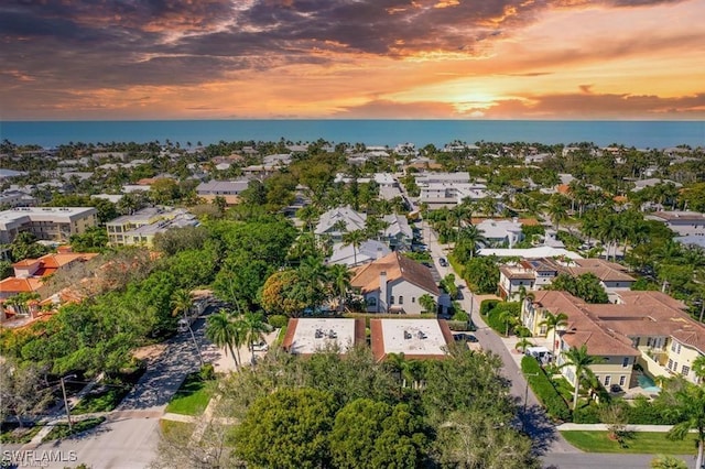 aerial view at dusk featuring a water view