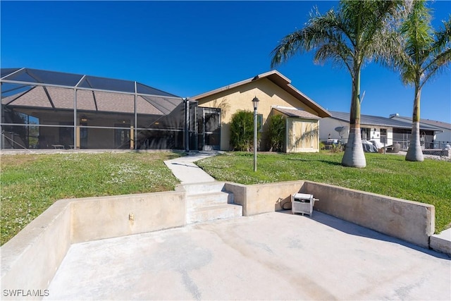 back of house with a lanai and a yard