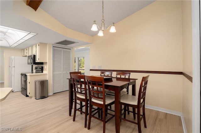 dining room with light wood-type flooring and an inviting chandelier