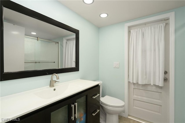 bathroom with an enclosed shower, vanity, and toilet