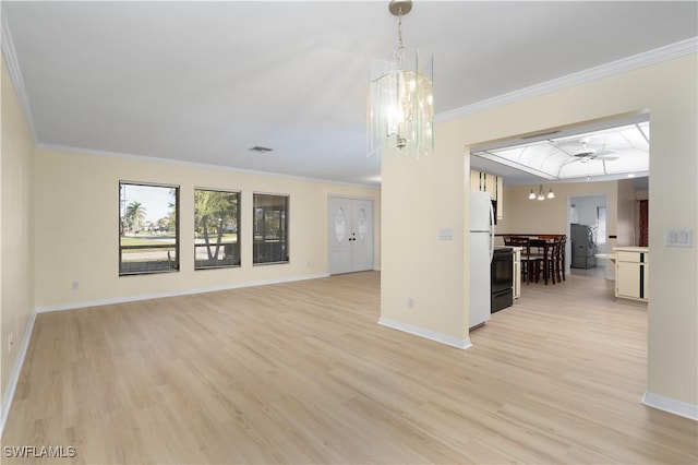 unfurnished living room with ceiling fan with notable chandelier, crown molding, and light hardwood / wood-style flooring